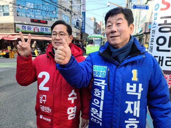 지난달 8일 부산 남구 못골시장에서 남구에 출마한 국민의힘 박수영 후보와더불어민주당 박재호 후보가 유세 중 만난 뒤 유권자에게 지지를 호소하고 있다. 연합뉴스