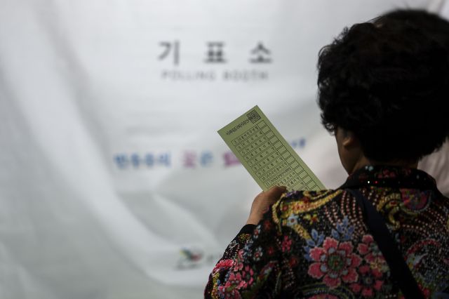 제22대 국회의원 선거일인 10일 서울 서대문구 홍제배드민턴장에 마련된 투표소를 찾은 유권자가 투표용지를 들고 기표소로 향하고 있다. 뉴시스