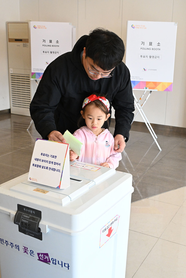 제22대 국회의원선거 본투표일인 10일 서울 광진구 기아자동차 대공원대리점에 마련된 능동제3투표소를 찾은 한 어린이가 투표함에 투표지를 넣고 있다. 권현구 기자