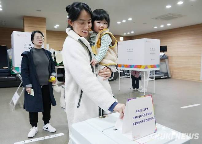 제22대 국회의원 선거일인 10일 경기 김포시 장기동 제7투표소에서 한 유권자가 아이와 투표하고 있다.
