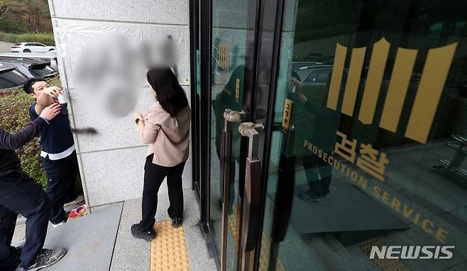 [서울=뉴시스] 김명년 기자 = 11일 오후 서울 서초동 서울고등검찰청 건물에 문재인 전 대통령과 서훈 전 국가정보원장을 비방하는 내용의 낙서를 하고 건물 창문에 돌을 던진 40대 남성이 경찰에 붙잡혔다. 사건 현장에서 청사 관계자들이 비닐막으로 낙서를 가리고 있다. 2024.04.11. kmn@newsis.com