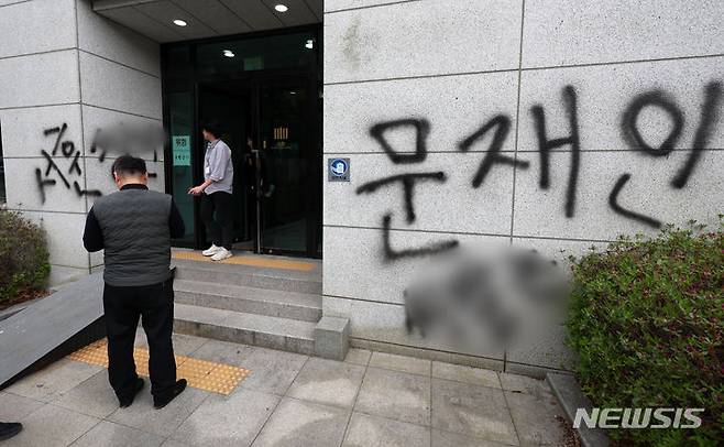 [서울=뉴시스] 김명년 기자 = 11일 오후 서울 서초동 서울고등검찰청 건물에 문재인 전 대통령과 서훈 전 국가정보원장을 비방하는 내용의 낙서를 하고 건물 창문에 돌을 던진 40대 남성이 경찰에 붙잡혔다. 사건 현장에서 청사 관계자들이 비닐막으로 낙서를 가리고 있다. 2024.04.11. kmn@newsis.com