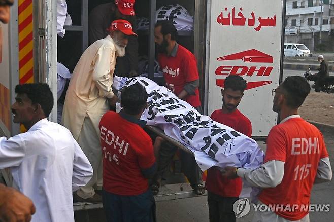 파키스탄 트럭 추락사고 사망자 주검 옮기는 봉사자들  [AFP 연합뉴스 자료사진. 재판매 및 DB 금지]