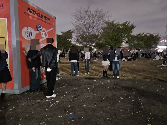 10일 금연 표시가 부착된 서울 여의도 한강공원 화장실 인근에서 시민들이 흡연을 하고 있다. 바닥에는 버려진 담배꽁초가 마구 흩어져 있다.[사진=이지은 기자]