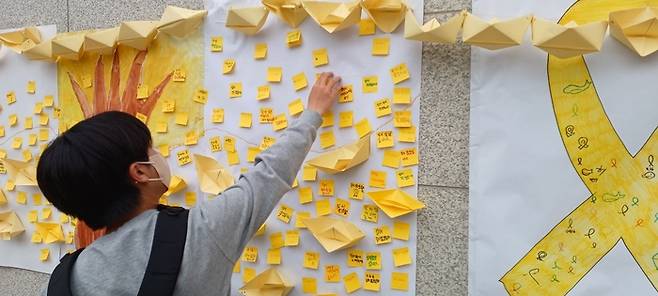 지난해 4월 한울중 학생이 학교 내 마련된 세월호 추모 공간에 추모 메시지를 붙이고 있다. 한울중 제공