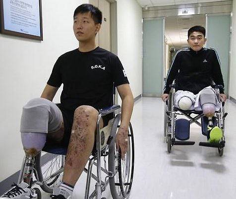 목함지뢰 피해 용사인 김정원(앞)·하재헌 하사가 2015년 사고 후 군 병원에서 치료받으며 재활하는 모습. 당시 의무병이던 박준호 상병은 현장에서 두 선임 부사관의 참혹한 부상 부위를 직접 지혈했다. /연합뉴스