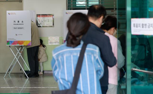 제22대 총선 투표일인 10일 서울 광진구 장안초등학교에 마련된 군자동 제5투표소에서 한 어린이가 투표를 지켜보고 있다. 뉴스1
