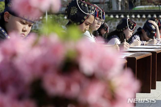 [서울=뉴시스] 최동준 기자 = 13일 서울 강남구 못골한옥어린이도서관에서 유생복장을 한 어린이들이 과거시험 방식으로 독서경연을 하고 있다. 2024.04.13. photocdj@newsis.com