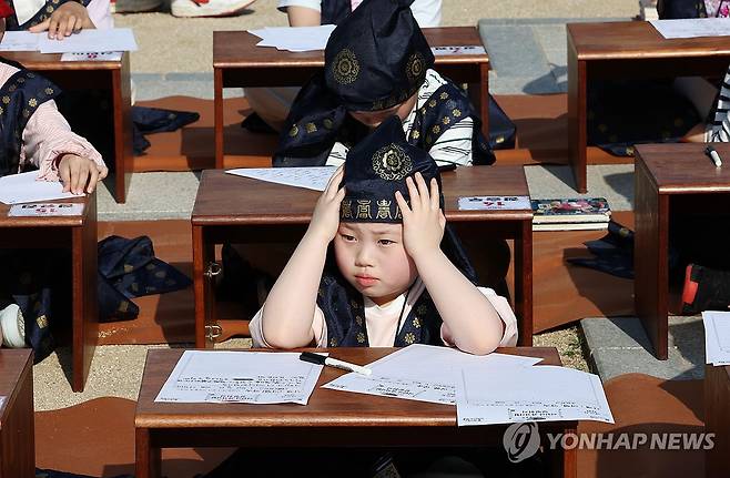 고뇌에 빠진 유생 (서울=연합뉴스) 김인철 기자 = 13일 서울 강남구 못골한옥어린이도서관에서 어린이 독서경연을 과거시험 방식으로 재현한 '일필휘지'에 참가한 어린이들이 시제에 맞춰 문제를 풀고 있다. 2024.4.13 yatoya@yna.co.kr