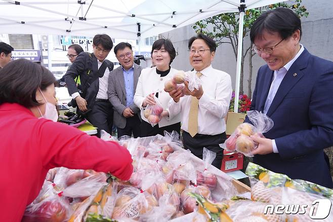 강기정 광주시장이 지난 12일 광산구 농협광주지역본부 주차장에 마련된 '농축산물 금요직거래장터 개장식'에 참석해 시민들에게 과일을 소개하고 있다.(광주시 제공)2024.4.14/뉴스1