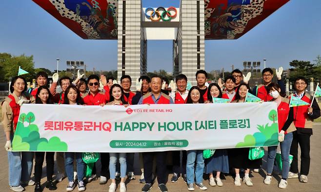 12일 서울 송파구 올림픽공원에서 김상현 롯데 유통군 총괄대표 부회장과 임직원들이 시티 플로깅 활동 후 기념사진을 촬영하고 있다. 롯데 유통군HQ 제공