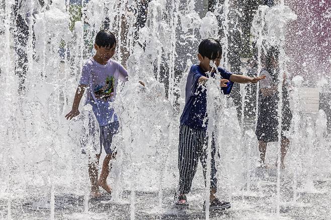 서울의 낮 최고기온이 29도까지 오른 14일 오후 서울 광화문 광장을 찾은 어린이가 분수에서 물놀이를 하며 더위를 식히고 있다. 전민규 기자