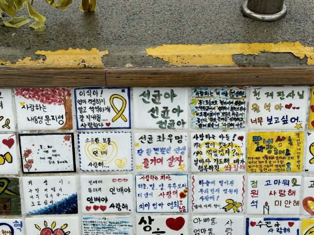 Tiles with messages from the bereaved families of the Sewol ferry disaster make up the "Wall of Memory," set up on a seawall near Jindo Port in Jindo, South Jeolla Province. (Lee Jung-joo/The Korea Herald)