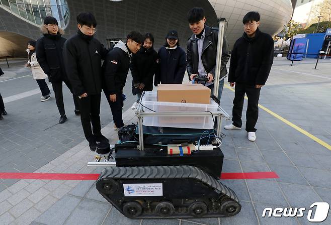 '2019 서울 스마트모빌리티 엑스포'를 찾은 시민들이 자율주행 로봇택배 시연을 보고 있다. 2019.11.8/뉴스1 ⓒ News1 박세연 기자