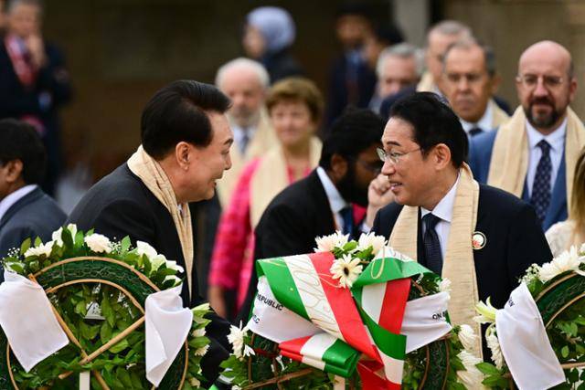 윤석열 대통령이 지난해 9월 10일 인도 뉴델리 간디 추모공원에서 주요 20개국(G20) 정상들과 함께 헌화하며 기시다 후미오(앞줄 오른쪽) 일본 총리와 대화하고 있다. 뉴델리=연합뉴스