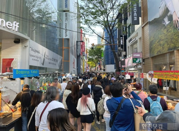 명동 노점 거리에 모여 음식을 둘러보고 사진을 찍는 외국인 관광객들. /사진=김세린 기자