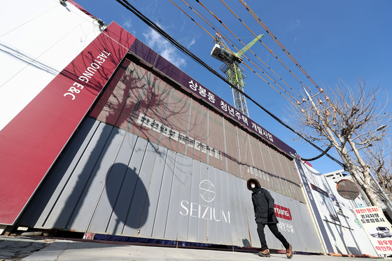 A pedestrian walks past a halted construction site of Taeyong E&C in Jungnang District in eastern Seoul on January 23. [YONHAP]