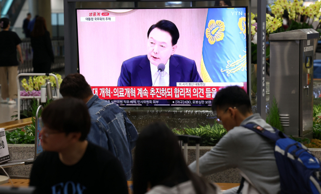 16일 오전 인천국제공항 제1여객터미널 입국장에서 공항 이용객들이 TV로 중계되는 윤석열 대통령의 국무회의 발언을 지켜보고 있다. 연합뉴스