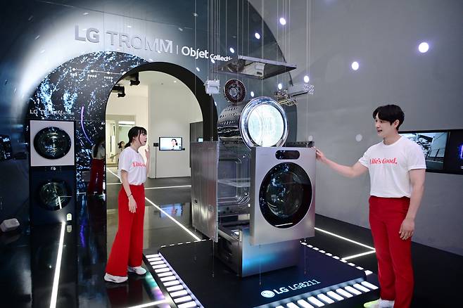 17일부터 3일간 서울 코엑스에서 열리는 월드IT쇼 2024에서 LG전자 모델들이 세탁부터 건조까지 한 번에 끝내는 'LG 시그니처 세탁건조기'의 ‘AI DD모터’와 ‘인버터 히트펌프’ 등 핵심 부품을 살펴보고 있다. [LG전자 제공]