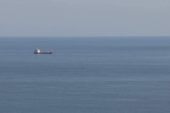 2024년 3월21일 전남 진도군 동거차도 보퉁굴산 정상에서 바라본 세월호 침몰 지점에 부표가 떠 있다. 그 뒤로 한 선박이 지나가고 있다. 한겨레 김영원 기자