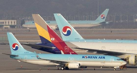 항공사 마일리지는 모으기도 어렵지만 쓰기는 더 어렵다. 차곡차곡 모은 마일리지로 보너스 항공권을 사는 게 가장 이득이지만 할당된 좌석이 많지 않다. 인천공항에 서 있는 대한항공과 아시아나항공. 중앙포토