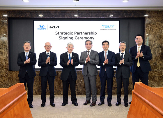 Executives from Hyundai Motor Group and Toray Industries including Akihiro Nikkaku, third from left, chairman of Toray, Chang Jae-hoon, fourth from left, CEO of Hyundai Motor, and Song Ho-sung, fifth from left, CEO of Kia, take a photo after signing an agreement at Hyundai's headquarters in Yangje-dong, southern Seoul. [HYUNDAI MOTOR]