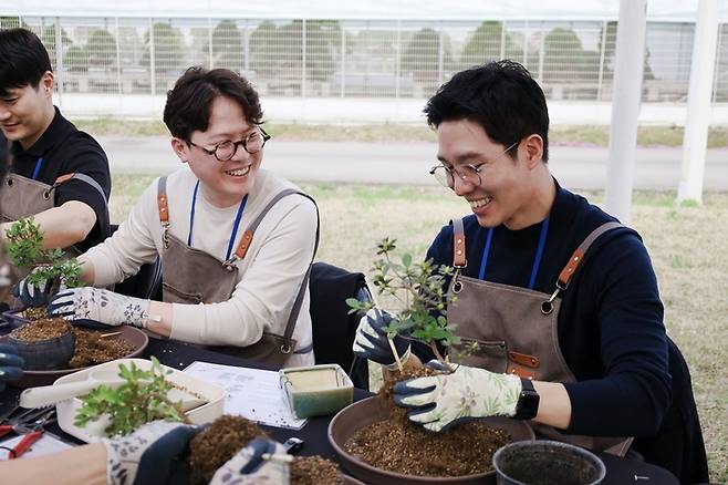 ‘웰럽 리더십 아카데미’에서 분재 만들기 체험을 하고 있는  피자알볼로 운영사 알볼로에프앤씨 이재욱 대표(왼쪽)와 고피자 임재원 대표.