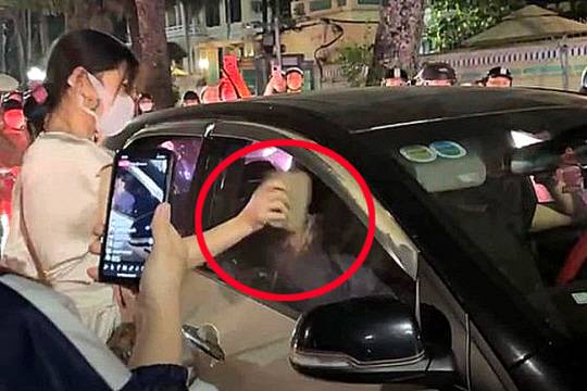 베트남의 한 도로에서 남편이 차에 불륜 상대를 태웠다고 의심한 아내가 차창을 벽돌로 내려치는 모습. SNS 캡처