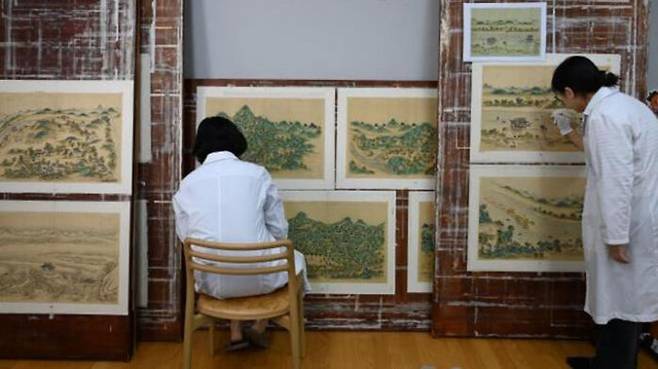 서울역사박물관 연구원들이 일본 해충에 의해 훼손된 ‘관서명승도첩’(關西名勝圖帖)을 복원하고 있다. (사진=서울시 제공)