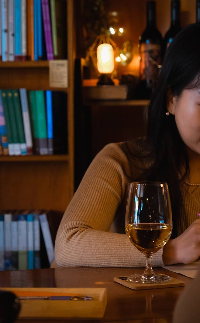 책방에서 술을 마시며 책을 읽고 있는 고객의 모습.