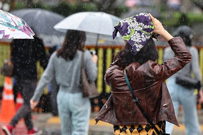 오는 20일 아침 제주·전남에서 비가 내리기 시작해 전국으로 확대될 것으로 보인다. 사진은 지난 15일 오전 서울 광화문광장에서 손수건으로 머리를 가리며 발걸음을 옮기고 있는 한 시민. /사진=뉴스1
