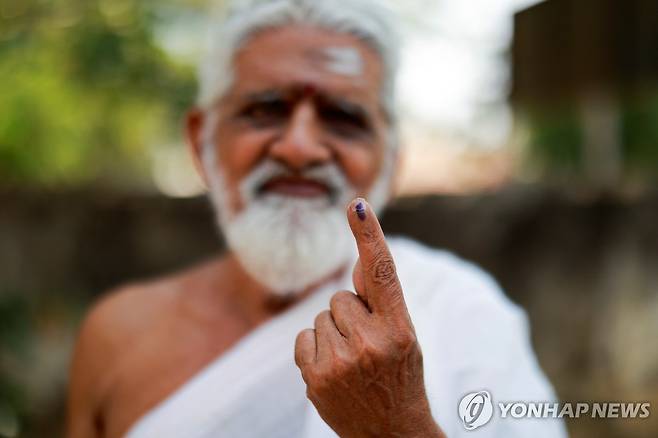 인도 총선 시작 (티루반나말라이[인도] 로이터=연합뉴스) 19일 인도 타밀나두주 티루반나말라이의 한 투표소에서 힌두교 성직자가 투표를 마친 후 특수 잉크가 묻은 손가락을 보이고 있다. 인도는 중복 투표를 막기 위해 기표한 유권자의 손가락에 한동안 지워지지 않는 잉크를 묻힌다. 2024.4.19. photo@yna.co.kr