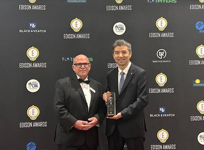 Kim Sang-jin (right), head of platform research at SK On, and Rob Manes, vice president of business development at Edison Universe, pose for a photo after winning a Bronze award at the 2024 Edison Awards at the Caloosa Sound Convention in Fort Myers, Florida, on Thursday. (SK On)
