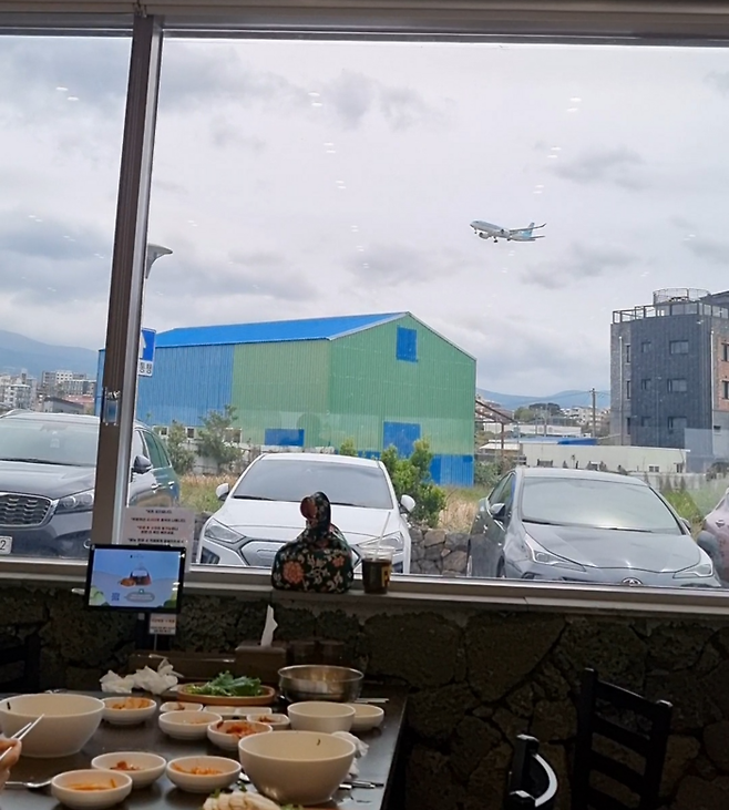 자매국수에서 보이는 제주공항에 착륙하는 비행기. 안병준 기자