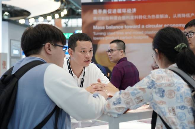 지난해 4월 중국 선전에서 열린 ‘차이나플라스 2023’에서 LG화학 직원이 고객에게 제품을 설명하고 있다.   LG화학 제공