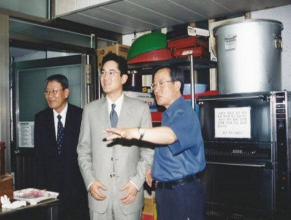 이재용 삼성전자 회장(당시 상무·가운데)이 지난 2003년 6월 서울 영등포 요셉의원을 방문한 자리에서 고(故) 선우경식 원장(오른쪽)의 안내를 받아 목욕실·세탁실·이발실을 둘러보고 있다. (사진=책 ‘의사 선우경식’ 제공)