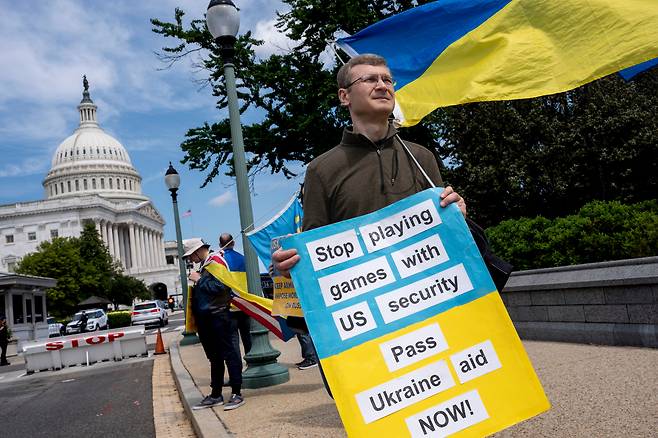 지난 20일 미국 워싱턴DC 의회의사당 앞에서 한 시민이 우크라이나 지원을 호소하는 피켓을 들고 있다. /AP 연합뉴스