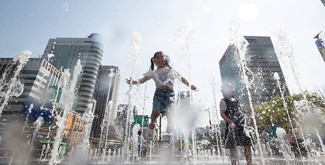 서울 낮 최고기온이 30도까지 오르는 등 초여름 날씨가 이어진 14일 서울 광화문광장 분수대에서 어린이들이 물놀이를 즐기며 더위를 식히고 있다./뉴스1