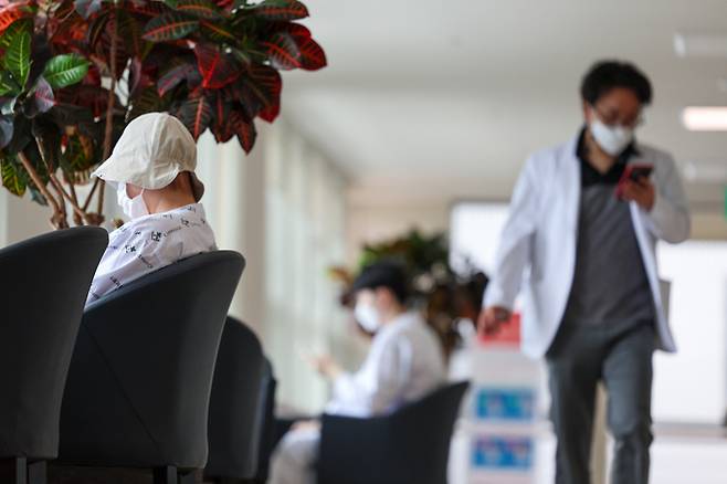 의대정원을 둘러싼 의정갈등이 이어지고 있는 가운데 21일 서울 한 대형병원에서 한 의료관계자가 흇식하는 환자들을 지나쳐 이동하고 있다. 정부가 일부 국립대 총장들의 제안을 받아들여 2025학년도 의대 증원분을 각 대학이 50~100% 범위에서 자율적으로 정하도록 결정했지만 의료계는 근본적인 해결책이 아니라며 원점 재검토를 촉구하고 있다.&nbsp; &nbsp; 연합뉴스