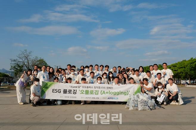 오토플러스 임직원들이 22일 서울 여의도 한강공원에서 샛강역에 이르는 6km 구간에서 쓰레기를 수거하는 ESG 캠페인 ‘오~플로깅’ 행사를 진행하고 기념 사진을 찍고 있다.(사진=오토플러스)