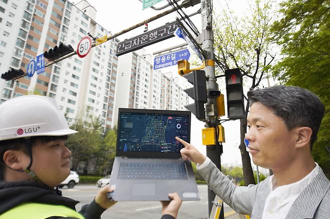 LG유플러스 관계자가 천안시에 설치된 긴급차량 출동 알림 전광판을 점검하는 모습. /LG유플러스 제공
