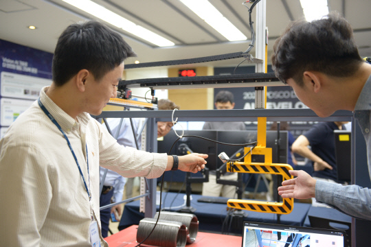 포스코DX AI기술센터 연구원들이 산업용AI가 적용된 크레인 모의장치를 시연하는 모습. 포스코DX 제공