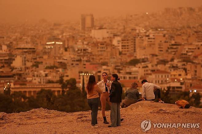 주황색으로 변한 그리스 아테네 (아테네 EPA=연합뉴스) 23일(현지시간) 그리스 아테네가 사하라 사막발 황사로 뒤덮인 가운데 사람들이 아크로폴리스를 산책하고 있다. 2024.04.23 photo@yna.co.kr