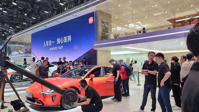 25일 중국 베이징 중국국제전람센터 순이관에서 열린 베이징 모터쇼의 샤오미 전시장에서 관람객들이 샤오미의 새 전기차 SU7을 둘러보고 있다. 베이징/최현준 특파원