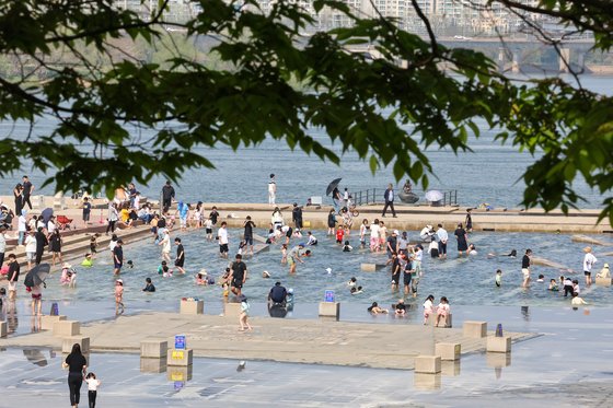 서울 한낮 기온이 29도까지 오르며 초여름 날씨를 보인 14일 오후 시민들이 서울 영등포구 여의도한강공원 물빛광장에서 물놀이를 즐기고 있다. 연합뉴스