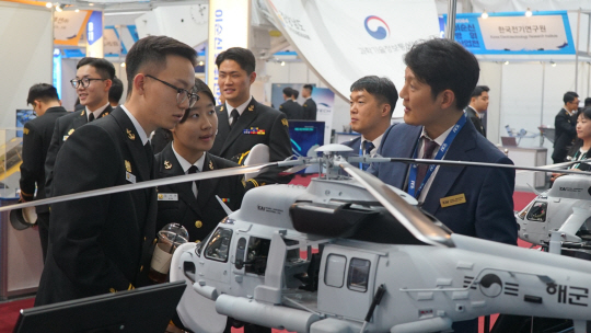 24일부터 경남 진해·창원 해군사관학교에서 열리고 있는 2024 이순신 방위산업전(YIDEX) 한국항공우주산업(KAI) 부스를 방문한 해군사관생도들이 소해헬기에 대한 설명을 듣고 있다. 한국항공우주산업 제공