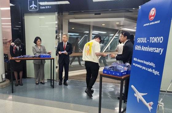 일본항공(JAL) 관계자들이 서울(김포)-도쿄(하네다) 노선 취항 60주년인 15일 서울 김포공항에서 하네다행 승객들에게 안전 운항을 약속하는 의미가 담긴 60주년 기념 한정판 키홀더를 증정하는 등 기념행사를 펼치고 있다. 연합뉴스