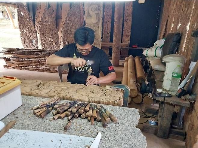 박담 박물관의 관계자가 나무 조각을 새기고 있다.