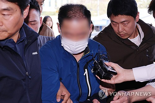 대법원 민원실에 전화해 "대법관을 죽이겠다"고 협박한 혐의로 긴급 체포된 50대 남성이 25일 오후 서울 서초경찰서로 압송되고 있다. 연합뉴스