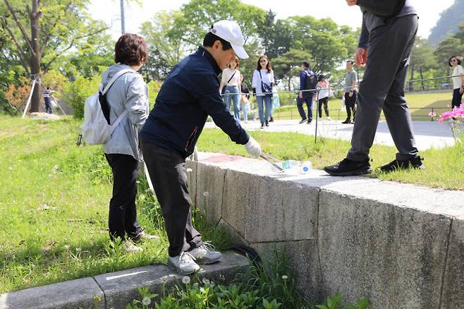 신대섭 서울지방우정청장과 직원들이 지난 27일 서울 남산 둘레길을 걸으면서 쓰레기 줍기 봉사활동(플로깅)을 하고 있다. (사진=서울지방우정청)